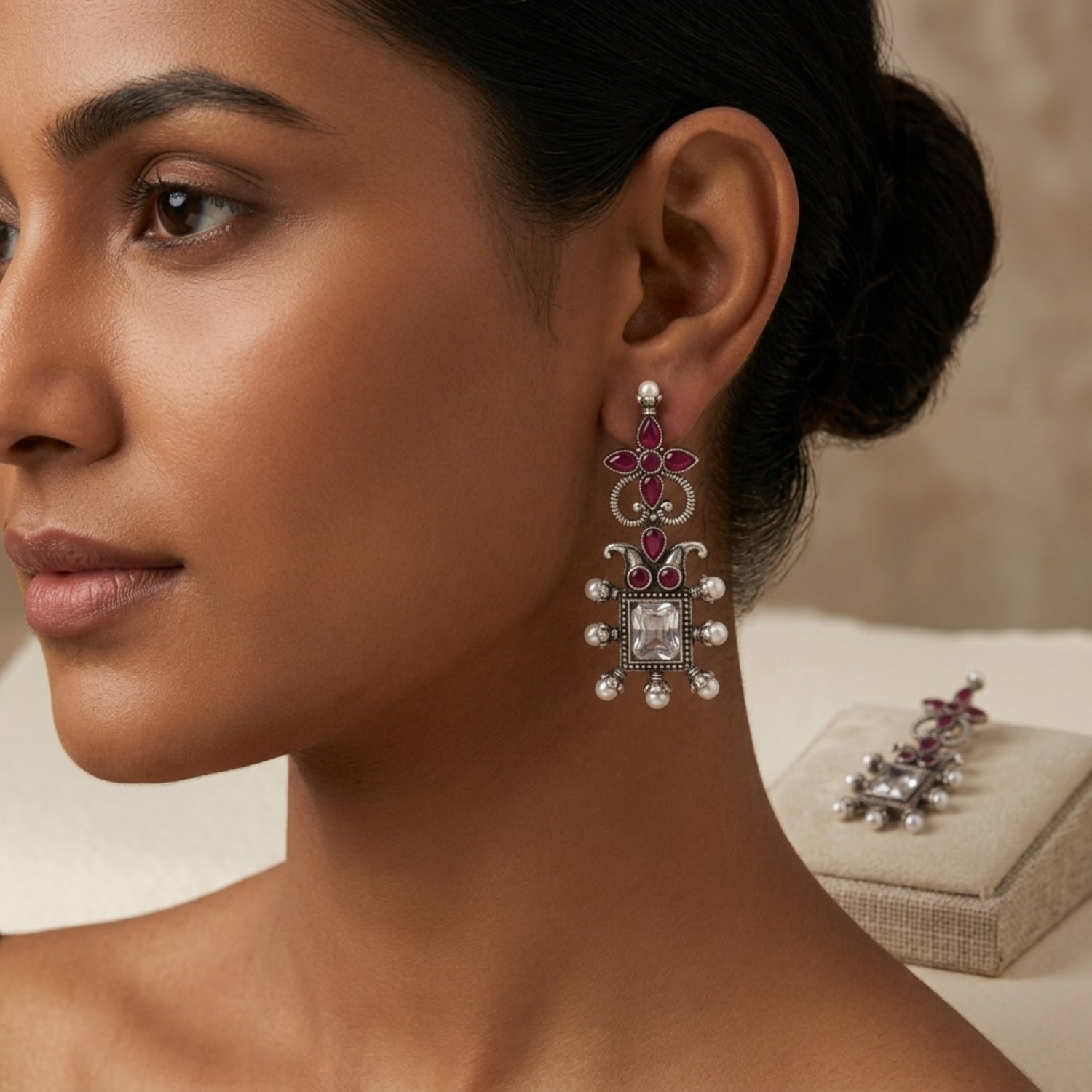 Close-up of a woman wearing an ornate earring with a matching box in the background.