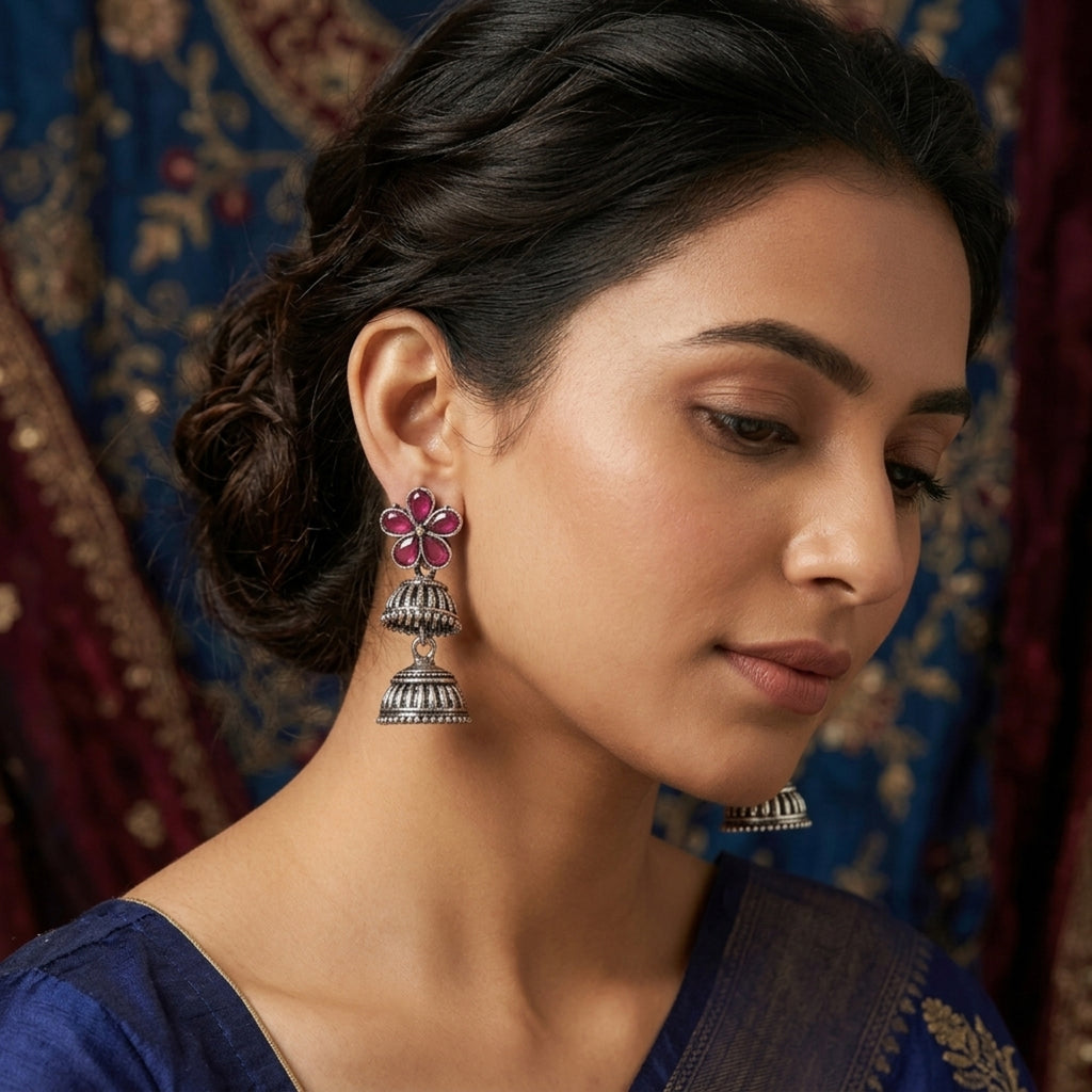 Woman wearing traditional earrings with a decorative background